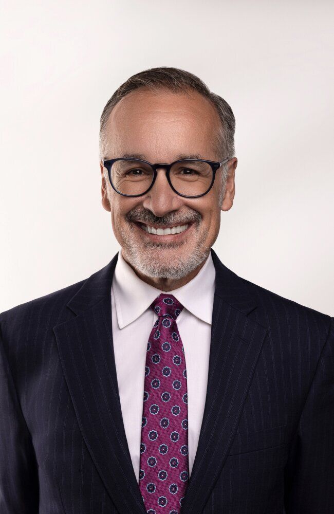 Smiling man in glasses and a suit.